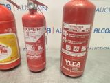 three fire extinguisors are lined up on a table
