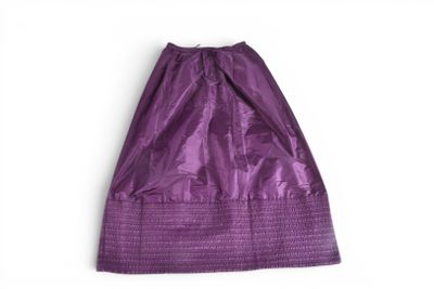 une jupe violette sur un cintre, sur fond blanc