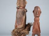 two carved wooden figures of a man and a woman