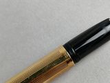 a close up of a fountain pen on a white surface