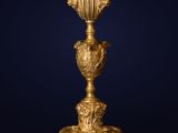 an antique gold vase on a stand against a dark blue background