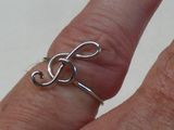 une personne tenant une bague sur laquelle figure le symbole « tre »