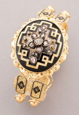 an image of a gold and black broochle with diamonds