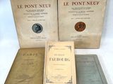 trois livres sont posés sur une table à fond blanc