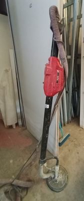 une image représentant un aspirateur rouge et noir dans une pièce