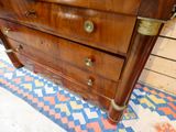 a wooden dresser with brass hardware on it in a room