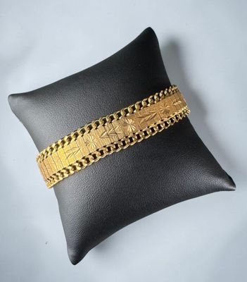 a black pillow with a gold bracelet on it