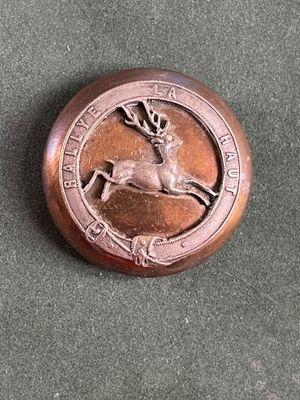 un bouton en bronze orné d'un cerf