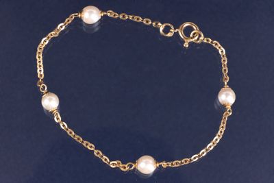 un gros plan d'un bracelet en or orné de perles