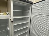 an open refrigerator in the corner of a kitchen