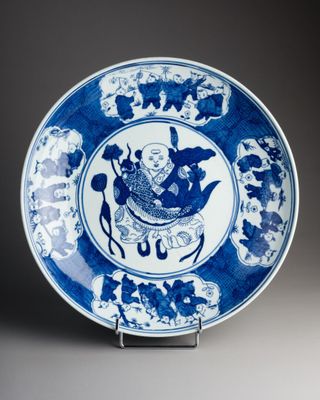 blue and white plate with a bird and flowers design on it