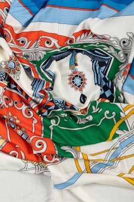 écharpe multicolore posée sur un lit, sur fond blanc