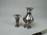 two silver vases sitting next to each other on a table