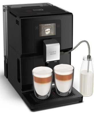 a close up of two cups of coffee next to a milk dispenser