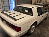 a white car parked in a garage with a rack on the roof