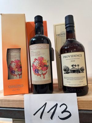 Trois bouteilles de vin sont posées sur une table, accompagnées d'une étiquette de prix