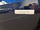 a person holding a sign that says vpauto on the side of the road