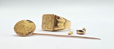 a gold ring with a gold coin next to it