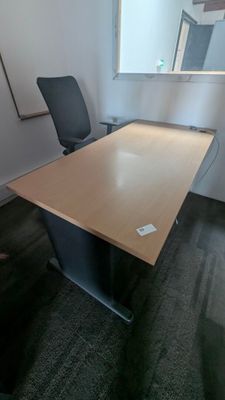 a desk with a chair and a mirror in the corner