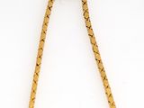 a close up of a necklace with a gold chain on a white surface