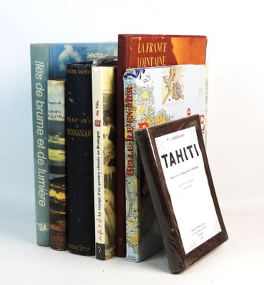 several books are stacked on top of each other on a white surface