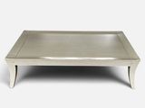a white coffee table with a metal tray on top of it
