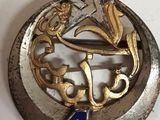 une broche en argent et en or surmontée d'une étoile