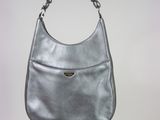 silver purse hanging from a chain on a white wall