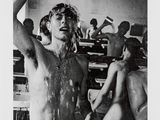 black and white photograph of a man standing in a room with a naked woman