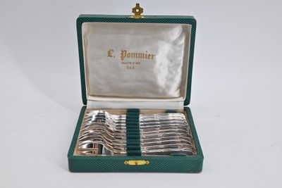 a green case with silverware in it on a white surface