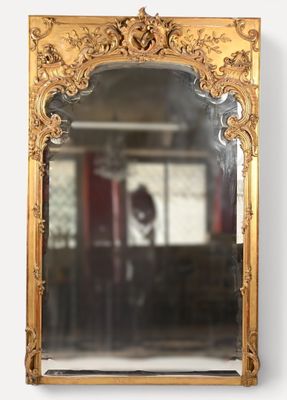 une image représentant un miroir à cadre doré accroché au mur d'une pièce