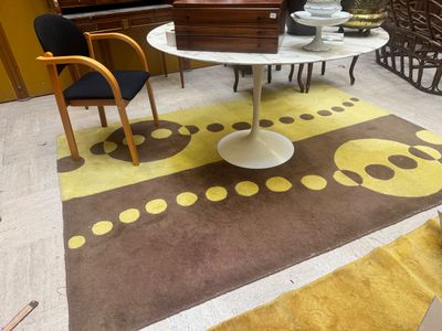 tapis jaune et marron dans un salon avec une table et des chaises