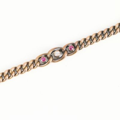 a close up of a gold chain with pink stones on it