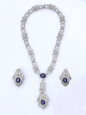 gros plan d'un collier et de boucles d'oreilles sur une surface blanche