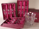 three wine glasses and a vase in a pink box