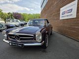 a brown mercedes parked in front of a building