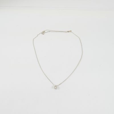 un collier blanc orné d'un petit diamant monté sur une chaîne