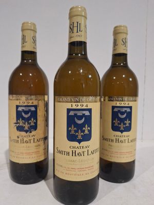trois bouteilles de vin posées sur une table l'une à côté de l'autre