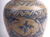a blue and white vase sitting on a white surface