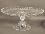 a clear glass cake plate with a flower design on it