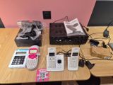 Plusieurs téléphones portables sont posés sur une table, à côté d'un ordinateur portable et d'un téléphone portable.