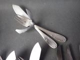 a lot of silver spoons and forks on a table