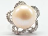 une image d'une bague en perles et diamants sur fond blanc