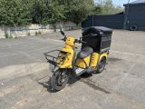 une moto jaune garée sur un parking à côté d'un immeuble