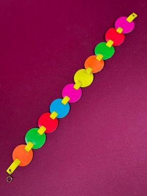 a close up of a colorful bracelet on a purple surface