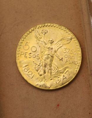 une pièce d'or posée sur une boîte marron