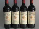 four bottles of red wine are lined up in a row