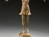 bronze statue of a woman standing on a pedestal with her arms outstretched