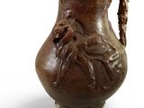 un vase marron orné d'une tête de lion