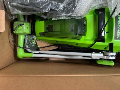 a box with a green corded vacuum in it
